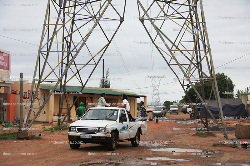 Carros passando pelo meio das torres da energia eléctrica