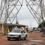 Carros passando pelo meio das torres da energia eléctrica