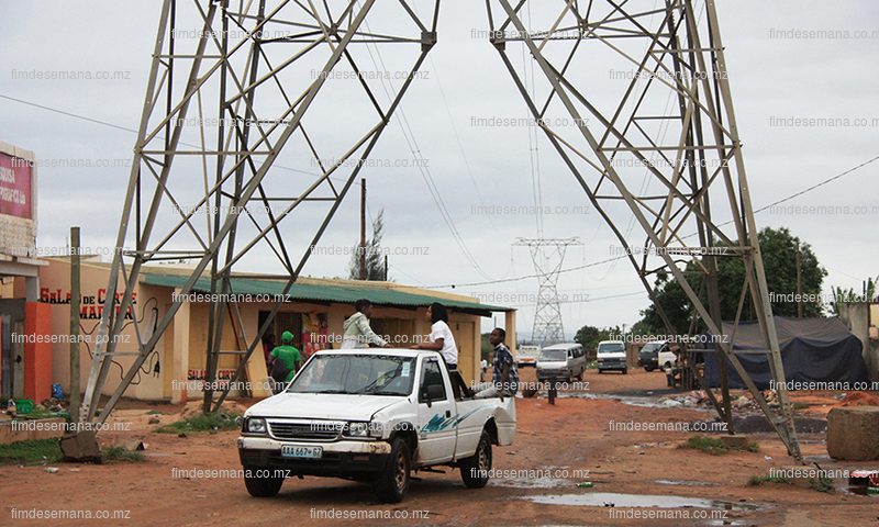 Carros passando pelo meio das torres da energia eléctrica