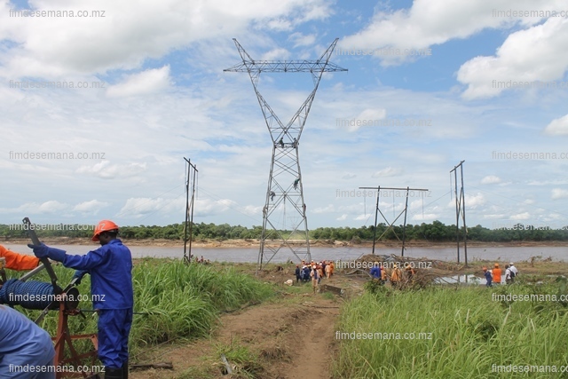 Técnicos da EDM durante montagem da linha no rio Licungo