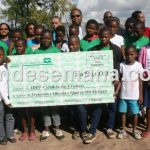 Alunos da Escola Comunit&aacute;ria ADPP Cidadela das Crian&ccedil;as exibindo o cheque