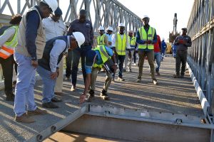 Colocação de tabuleiros sobre a ponte metálica em Impaputo