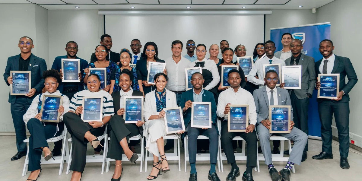 Foto de familia com os 21 jovens recém graduados e membros da Comissão Executiva do Banco